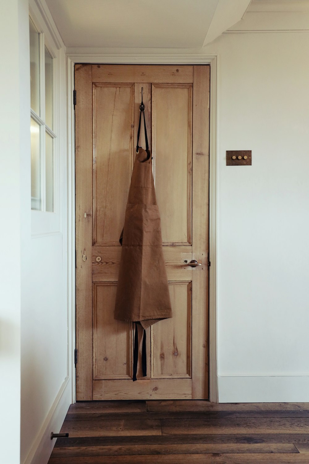 abrigo marrón colgado en la puerta