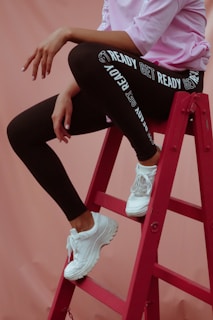 person in black leggings and white sneakers