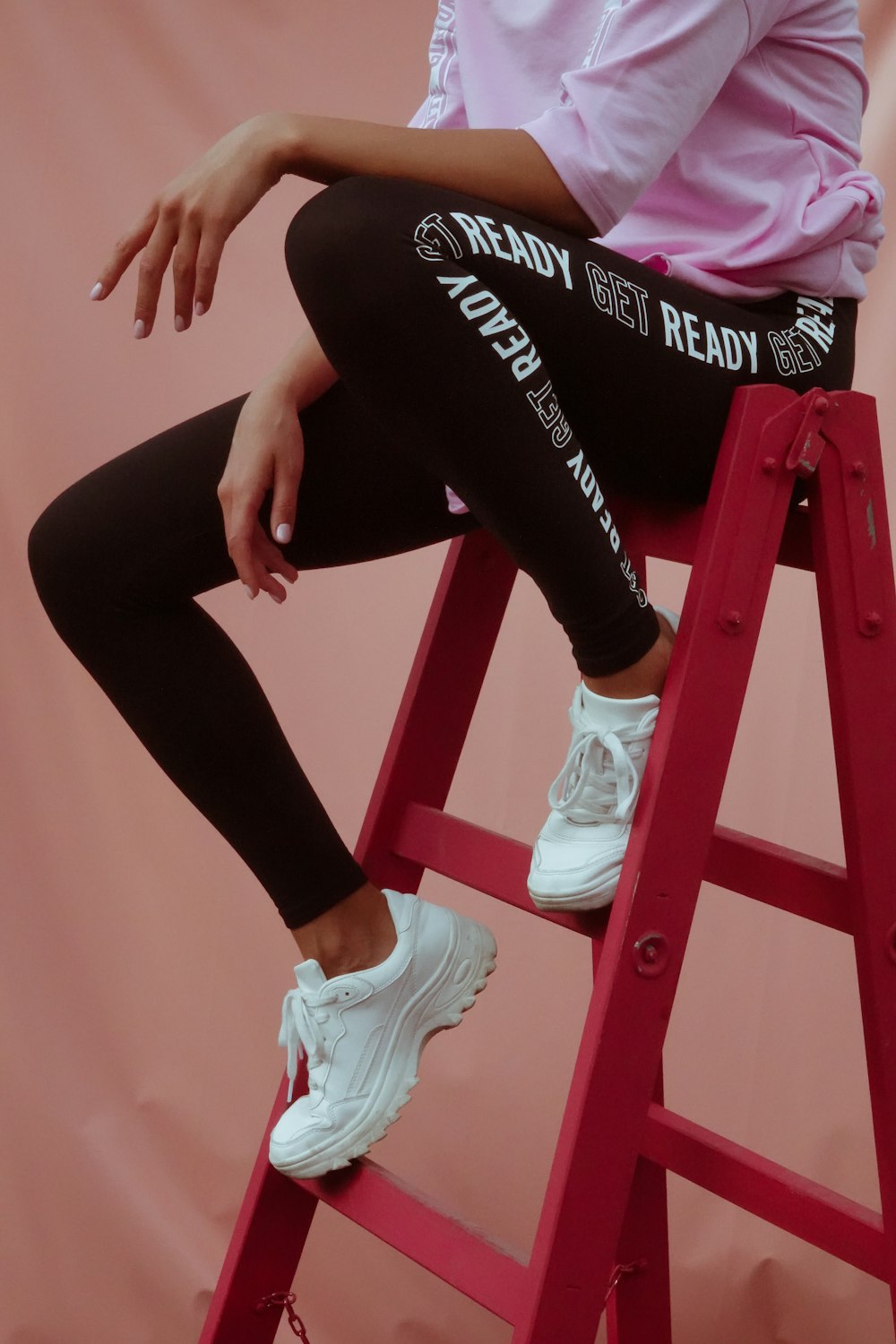 person in black leggings and white sneakers