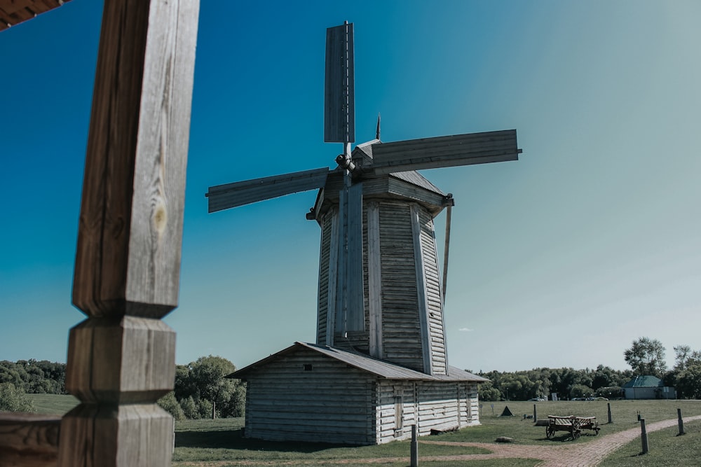 brown wooden windmill on green grass field during daytime