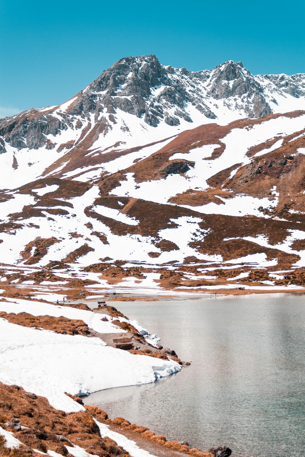 Montaña cubierta de nieve cerca del cuerpo de agua durante el día