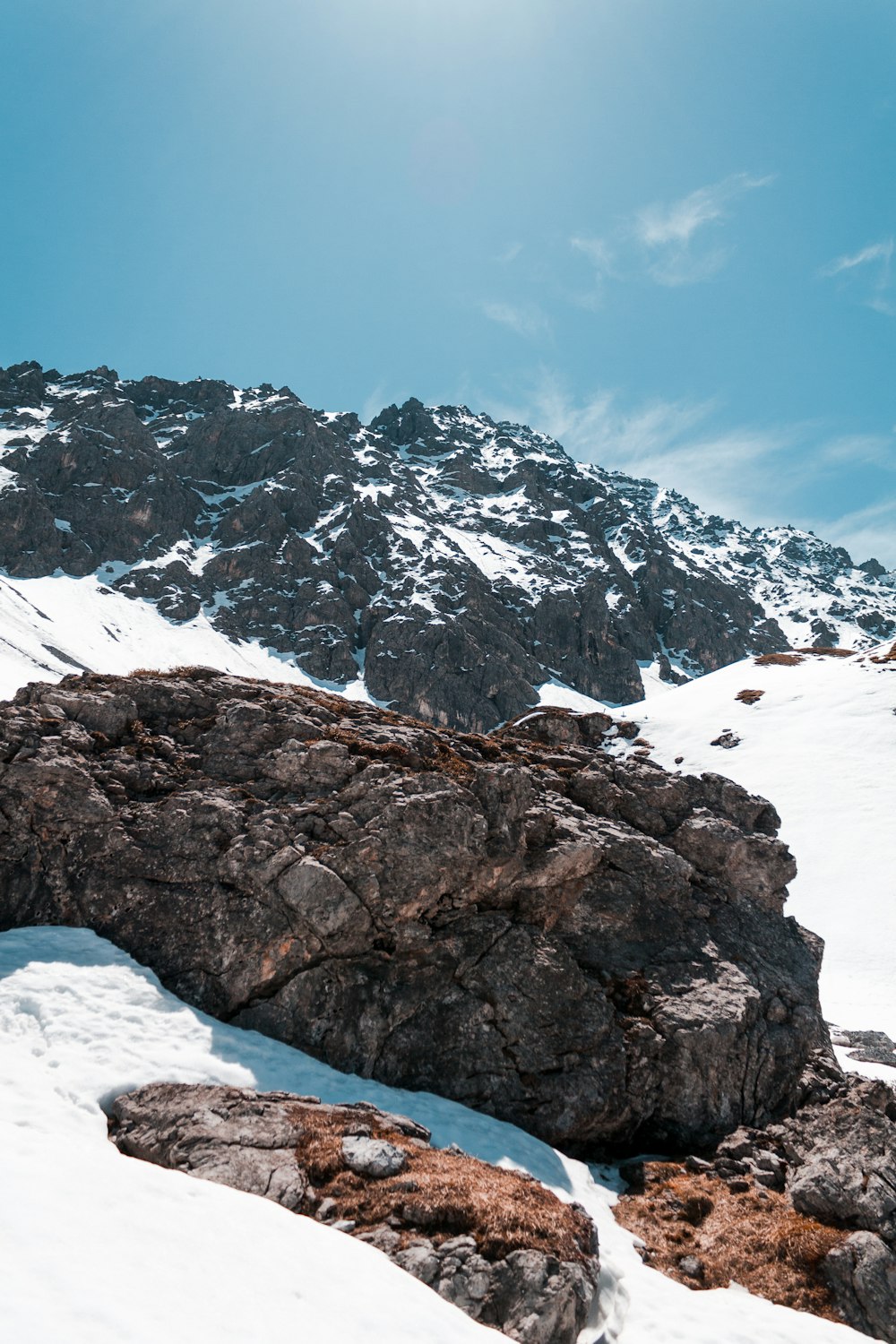 日中の雪に覆われた地面の茶色の岩層