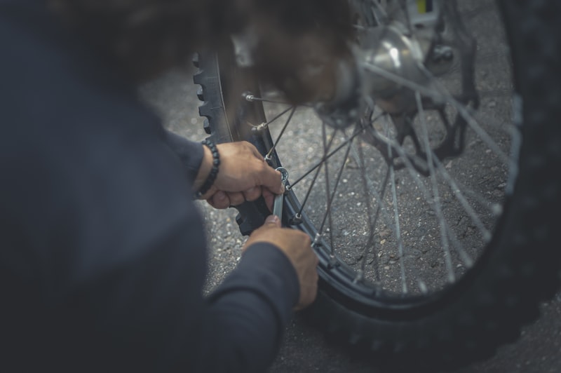 Person hält ein Fahrradlaufrad in der Hand