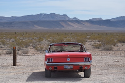 A sleek convertible parked near Saguaro National Park under a bright blue sky.