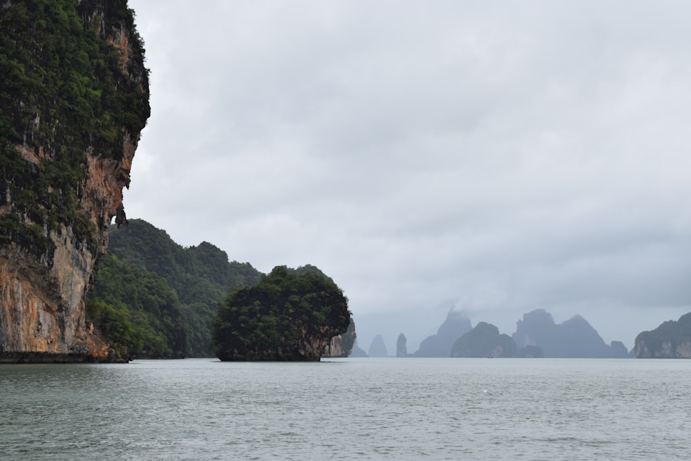 green and brown mountain beside body of water during daytime