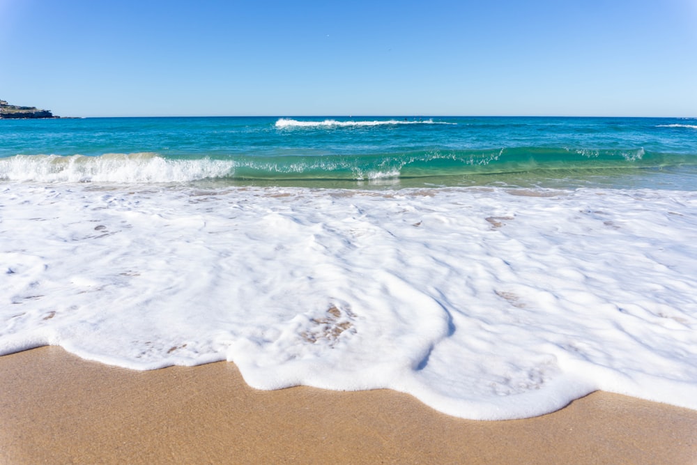 sea waves crashing on shore during daytime