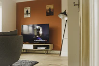 black flat screen tv turned on near white and black torchiere