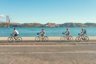 man in red shirt riding bicycle on road during daytime