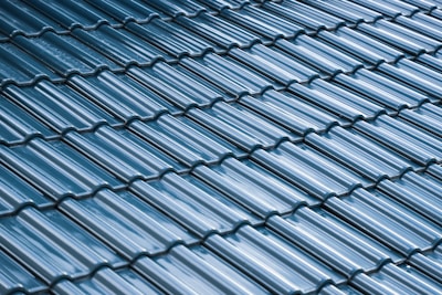 Close-up of a roof replacement showing neat, new dark blue roofing tiles.