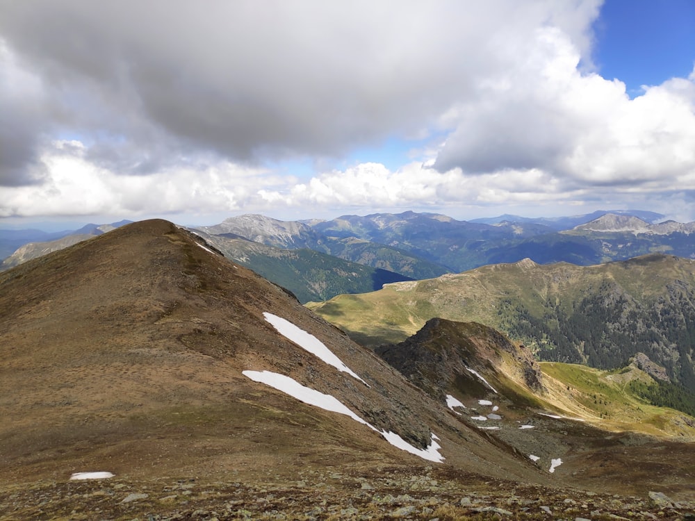 brown and green mountains under white clouds during daytime