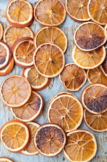 sliced orange fruits on white wooden table
