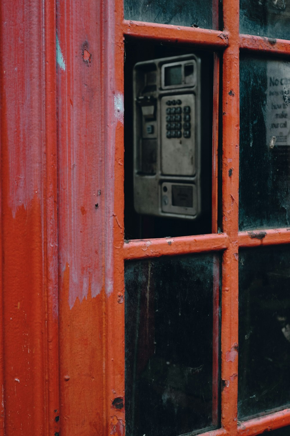 black telephone booth on red wooden door