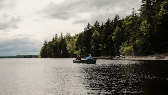 person riding on red boat on river during daytime in Saint-Théophile Canada