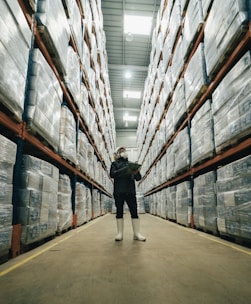 man in black jacket and black pants walking in an ecommerce warehouse