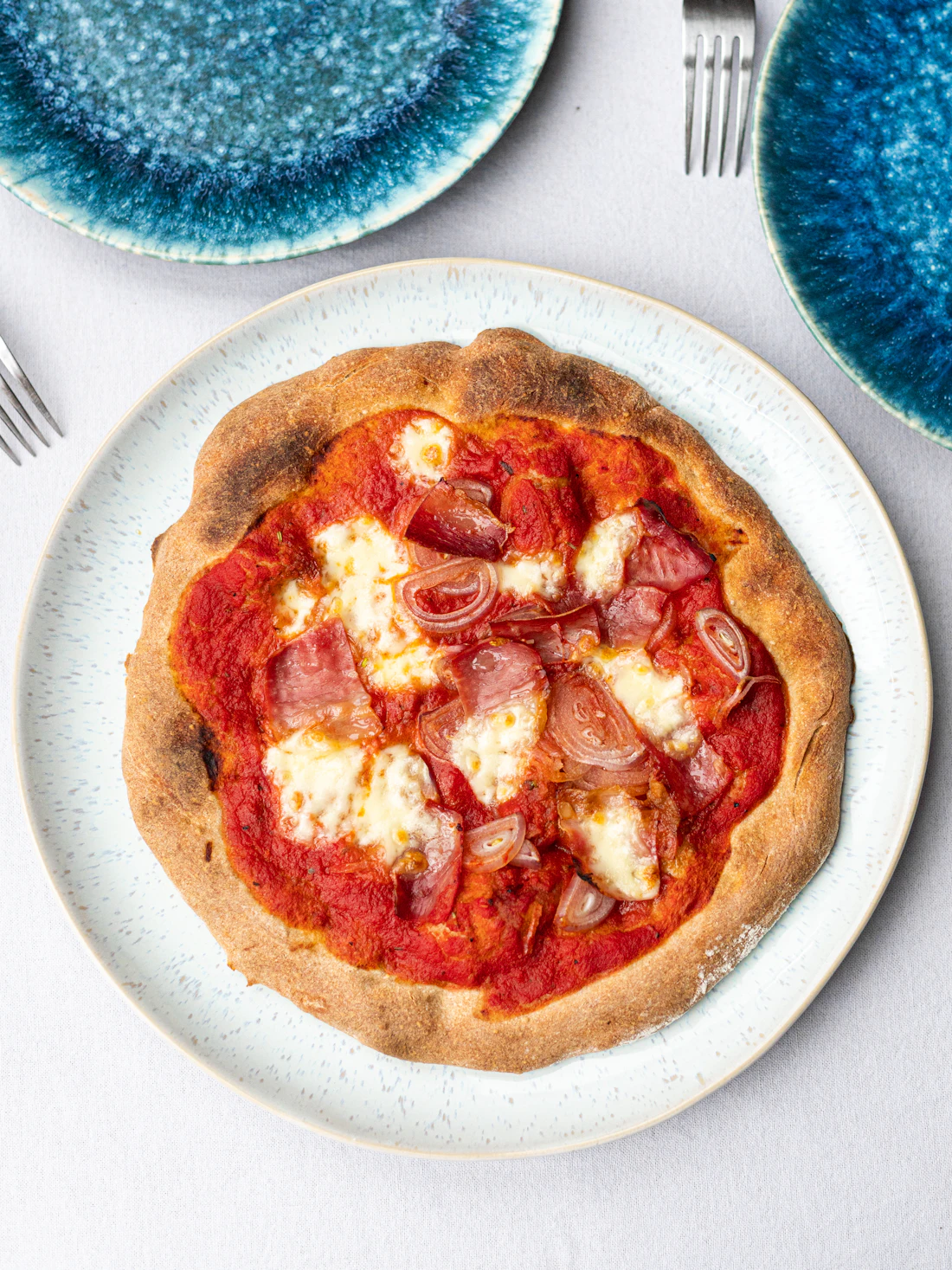 Pizza con salsiccia e cipolla rossa vista dall'alto