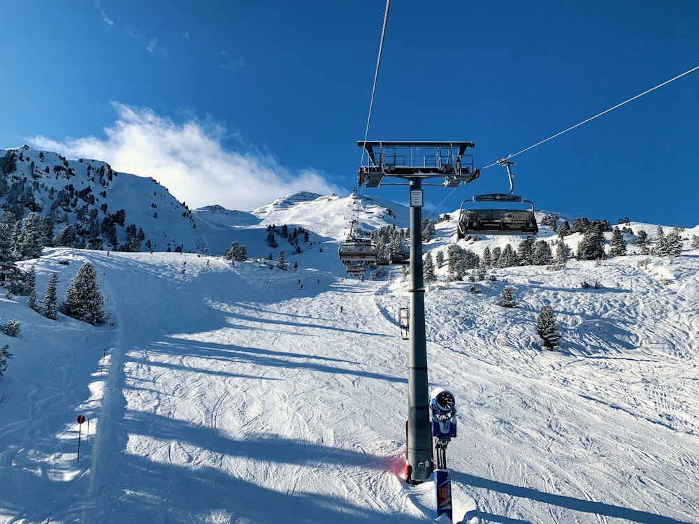 昼間の雪山を越えるケーブルカー