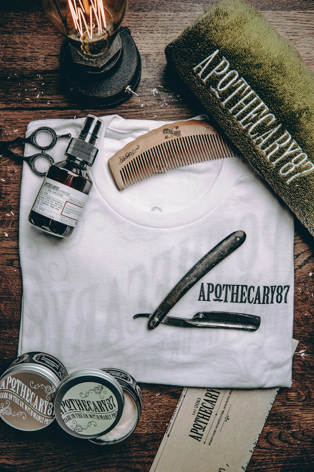 black and white labeled bottle beside black hair comb and black hair comb