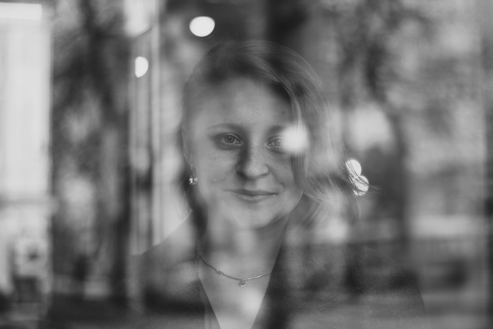 grayscale photo of woman with flower on her ear