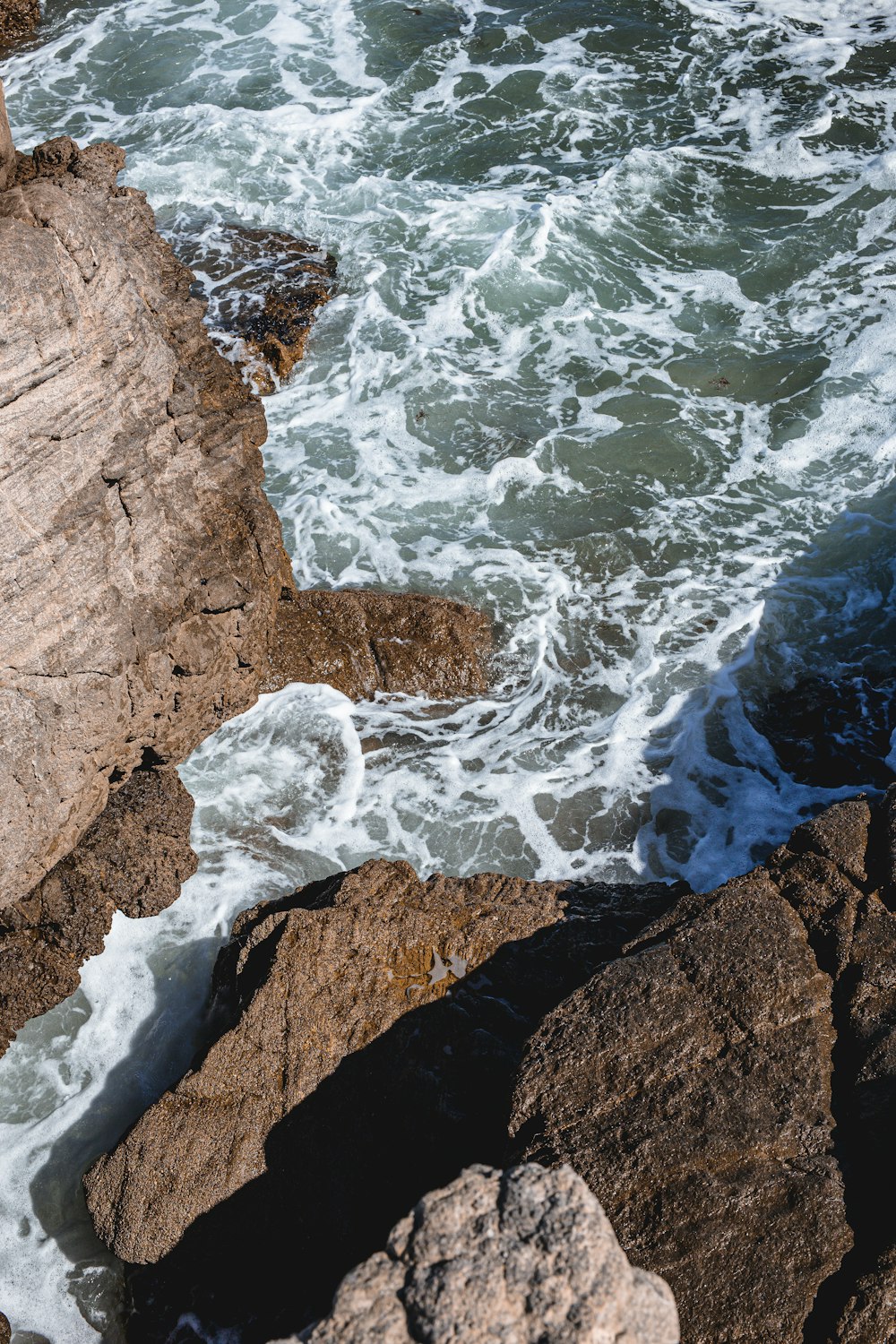 brown rock formation near body of water during daytime