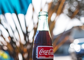 coca cola glass bottle on brown wooden table