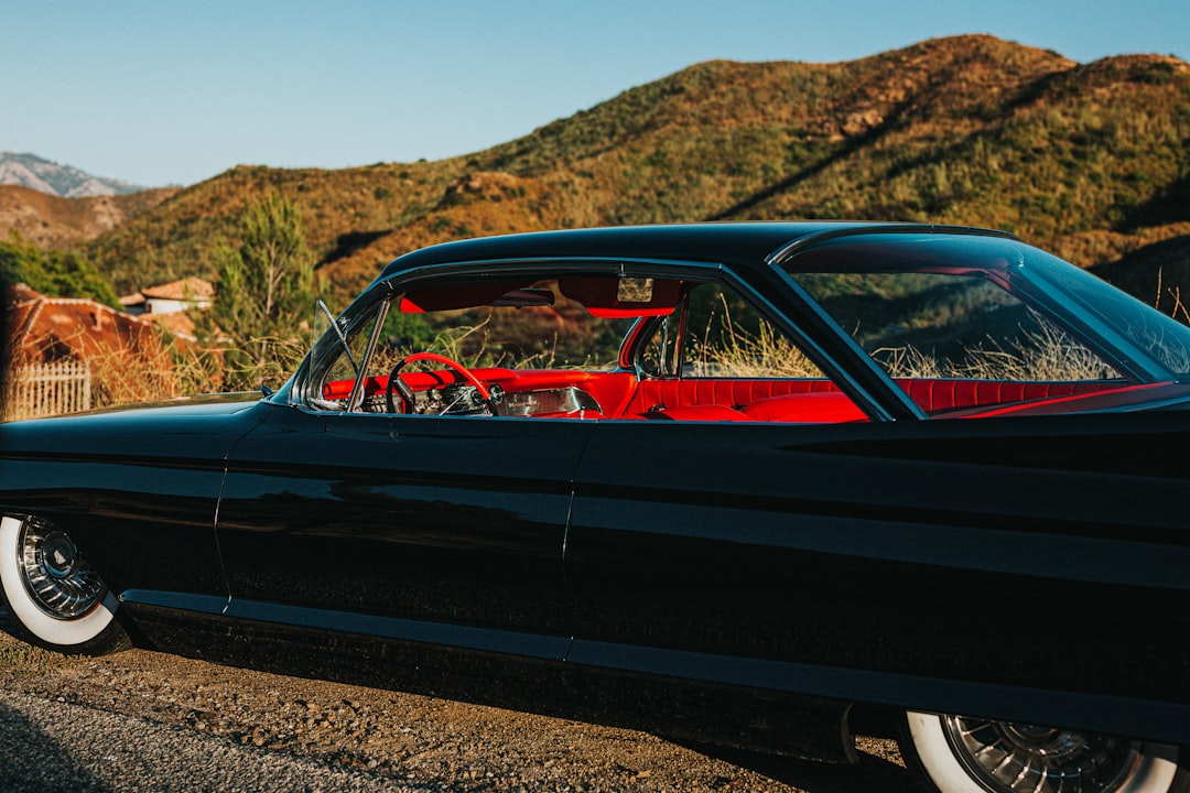 red coupe on brown soil during daytime