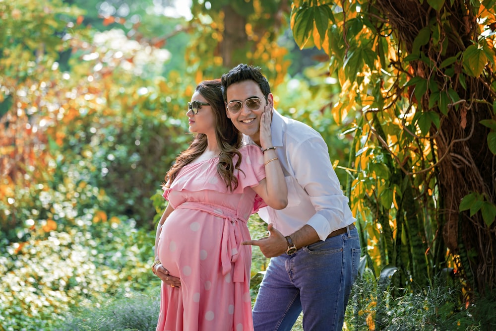 woman in pink dress standing beside man in white dress shirt