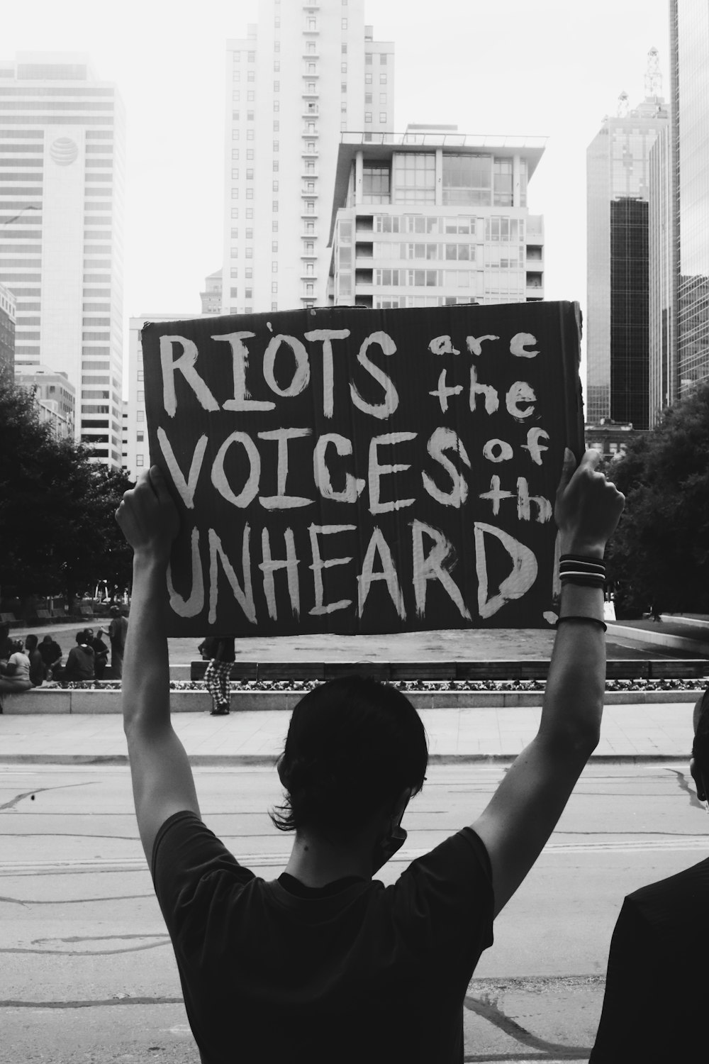 grayscale photo of man holding black and white wall graffiti