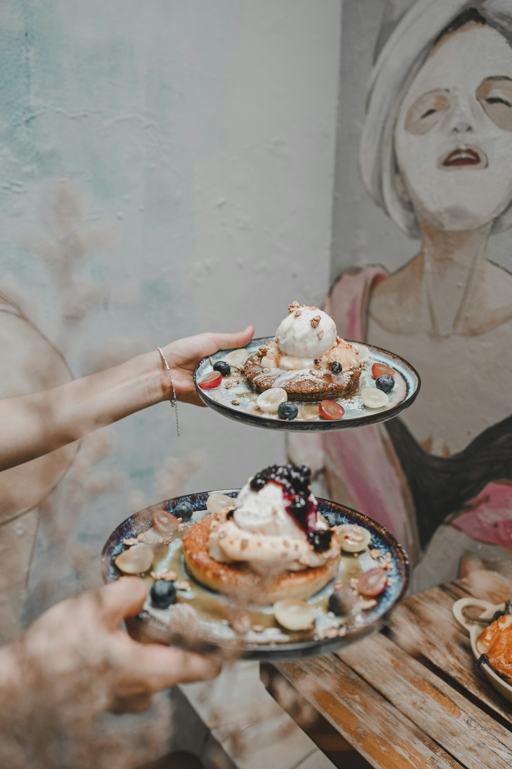 person holding white ceramic plate with white icing and chocolate cake