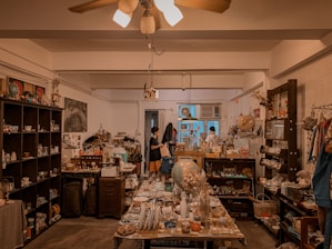 A cozy, warmly lit room with a Trash Panda Lady candle glowing on a rustic wooden table surrounded by quirky, eclectic decor.