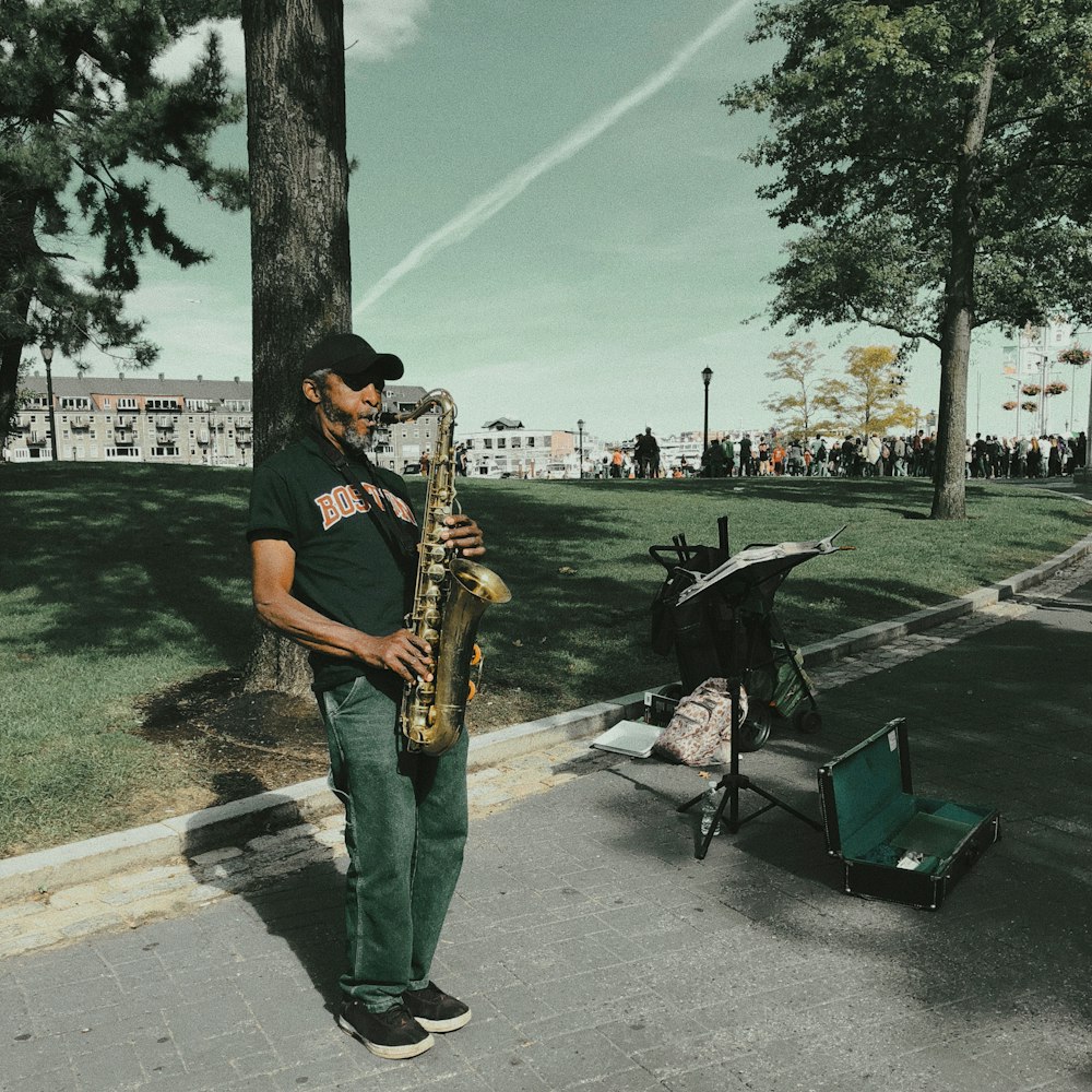 man in black t-shirt playing saxophone