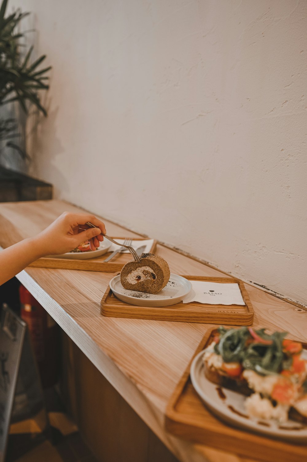 person slicing cake on brown wooden chopping board