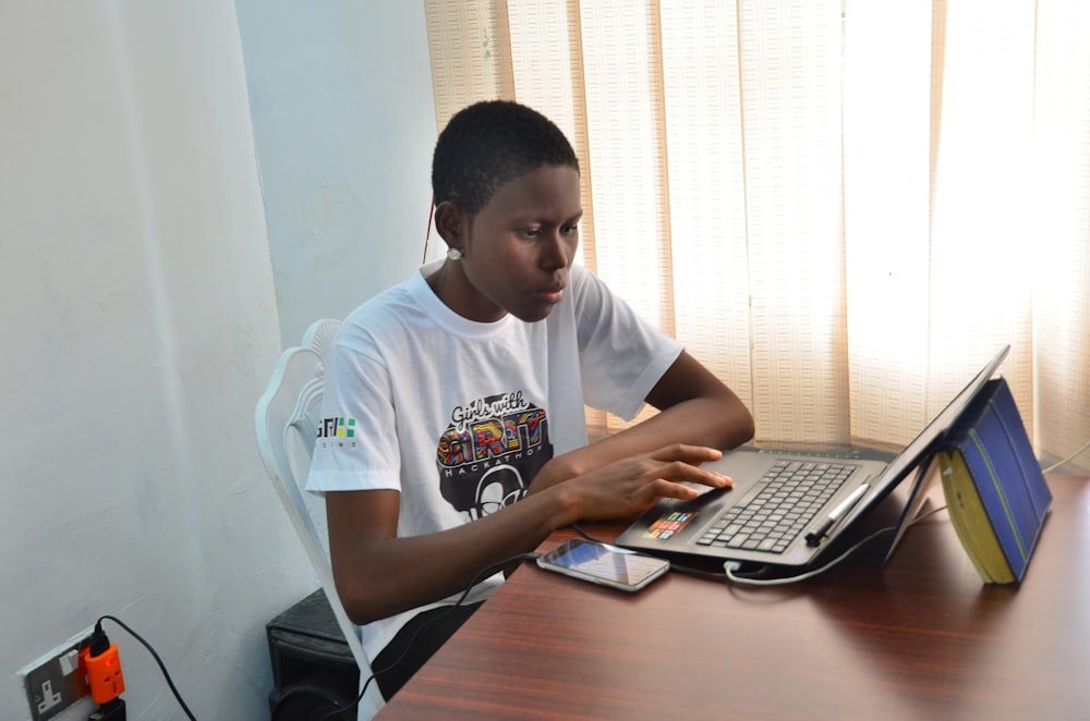 man in white crew neck t-shirt using black laptop computer