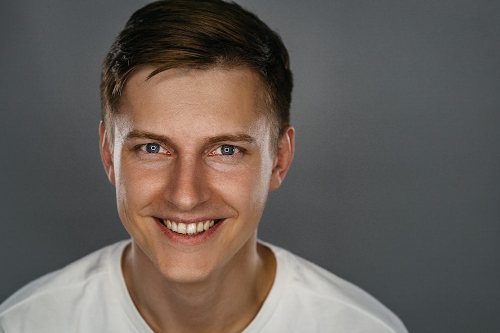 man in white crew neck shirt smiling