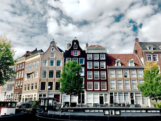 brown and white concrete building under cloudy sky during daytime in Anne Frank House Netherlands