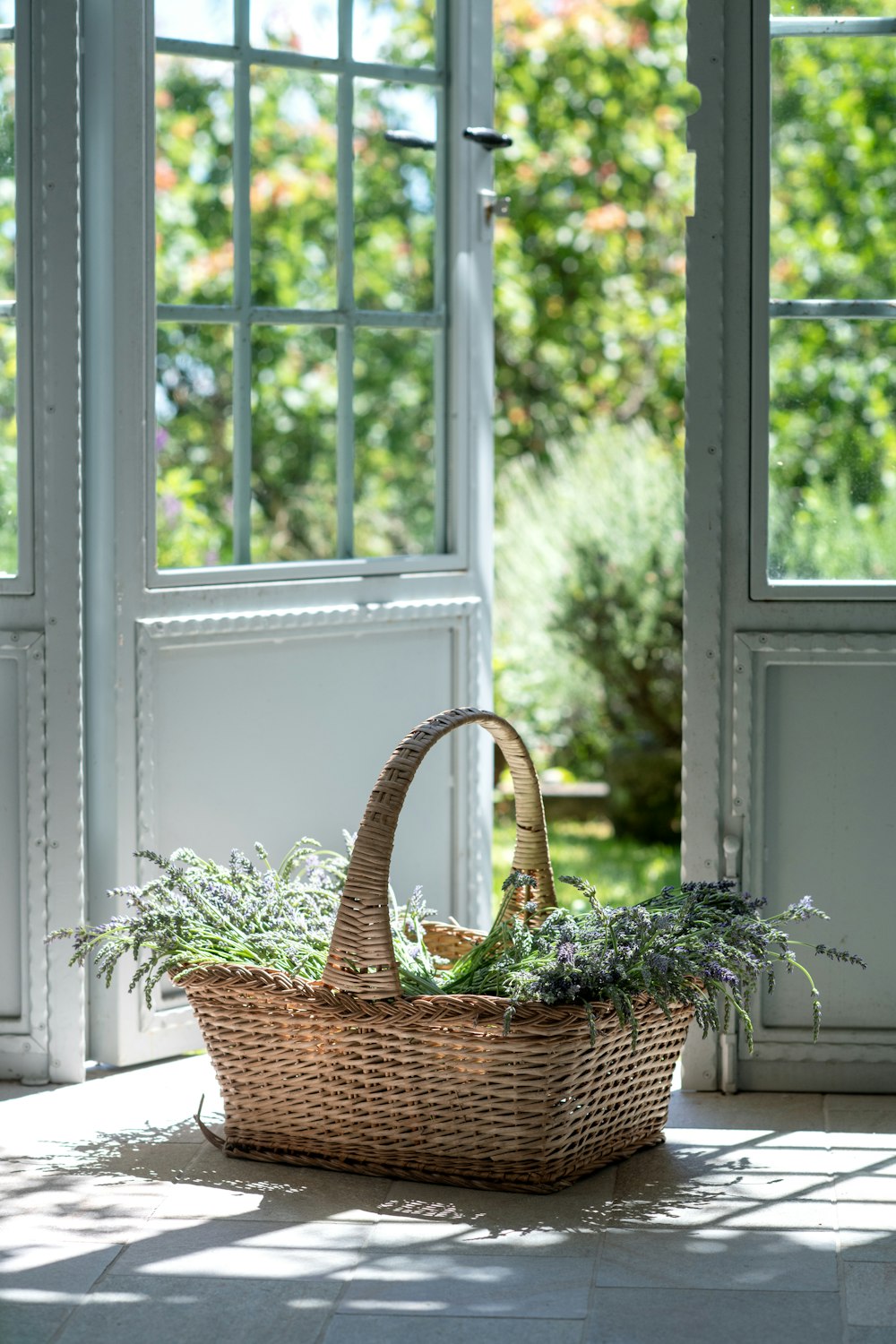 cesta tecida marrom na janela de madeira branca