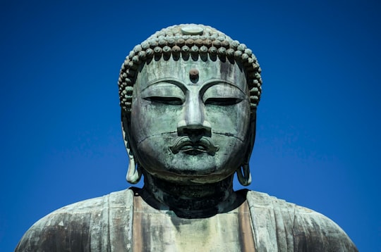 grey concrete statue under blue sky during daytime in Kōtoku-in Japan