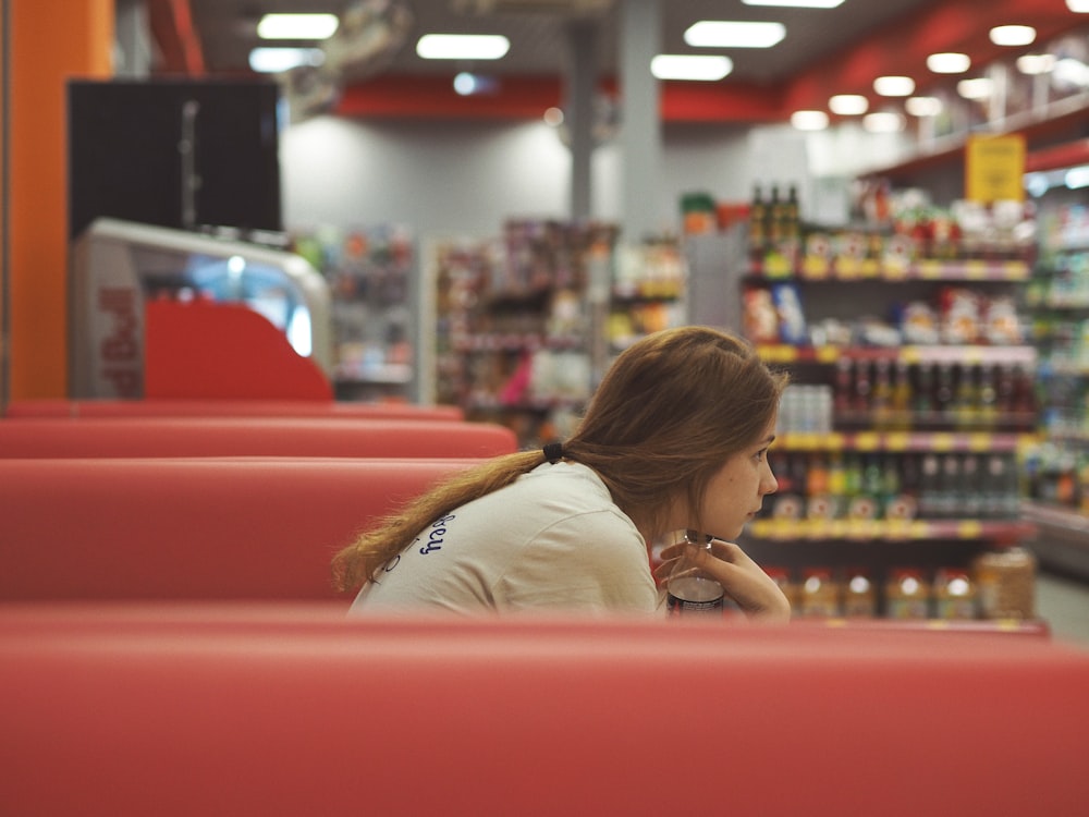 woman in white shirt sitting on red chair