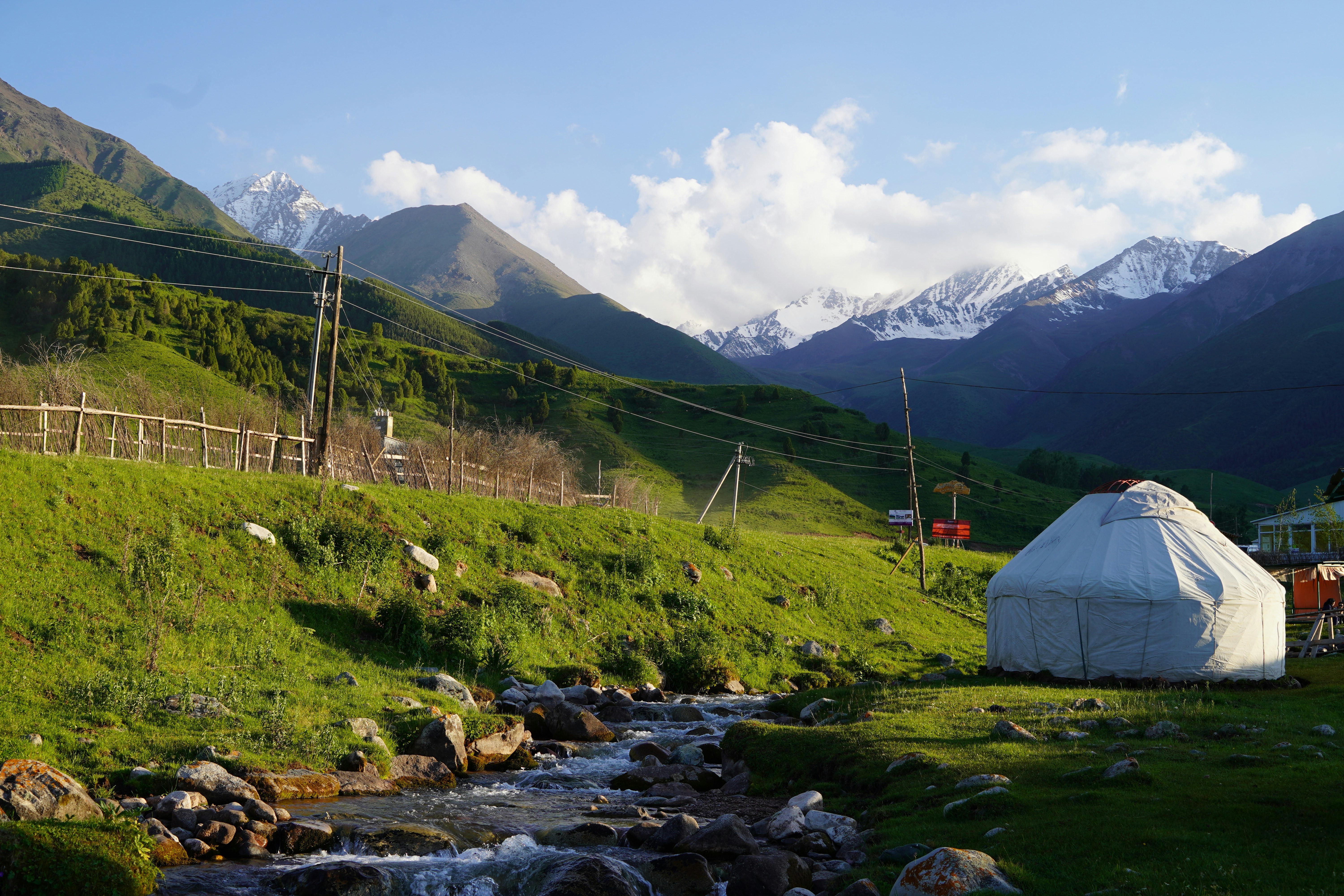 white tent on green grass field near mountain during daytime