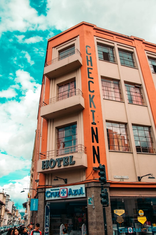 brown and white concrete building under blue sky during daytime in Cuenca Ecuador