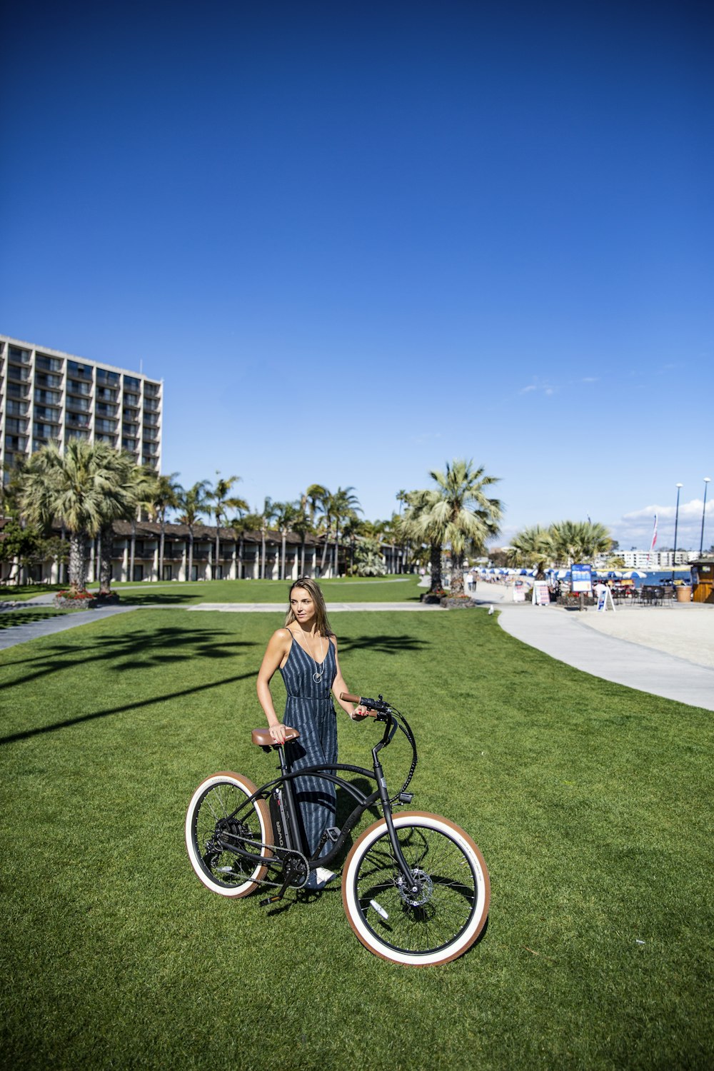 woman in black tank top riding on bicycle on green grass field during daytime