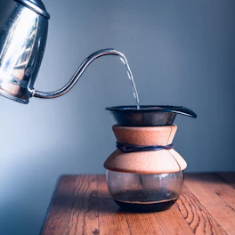 stainless steel kettle on brown wooden table