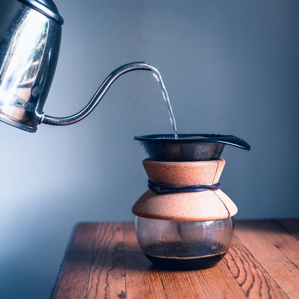 stainless steel kettle on brown wooden table