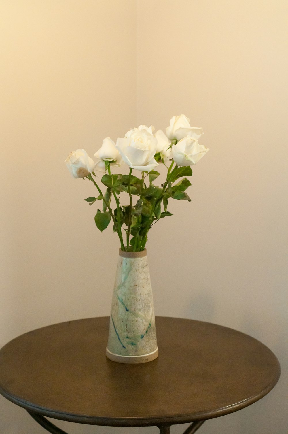 white flowers in blue glass vase