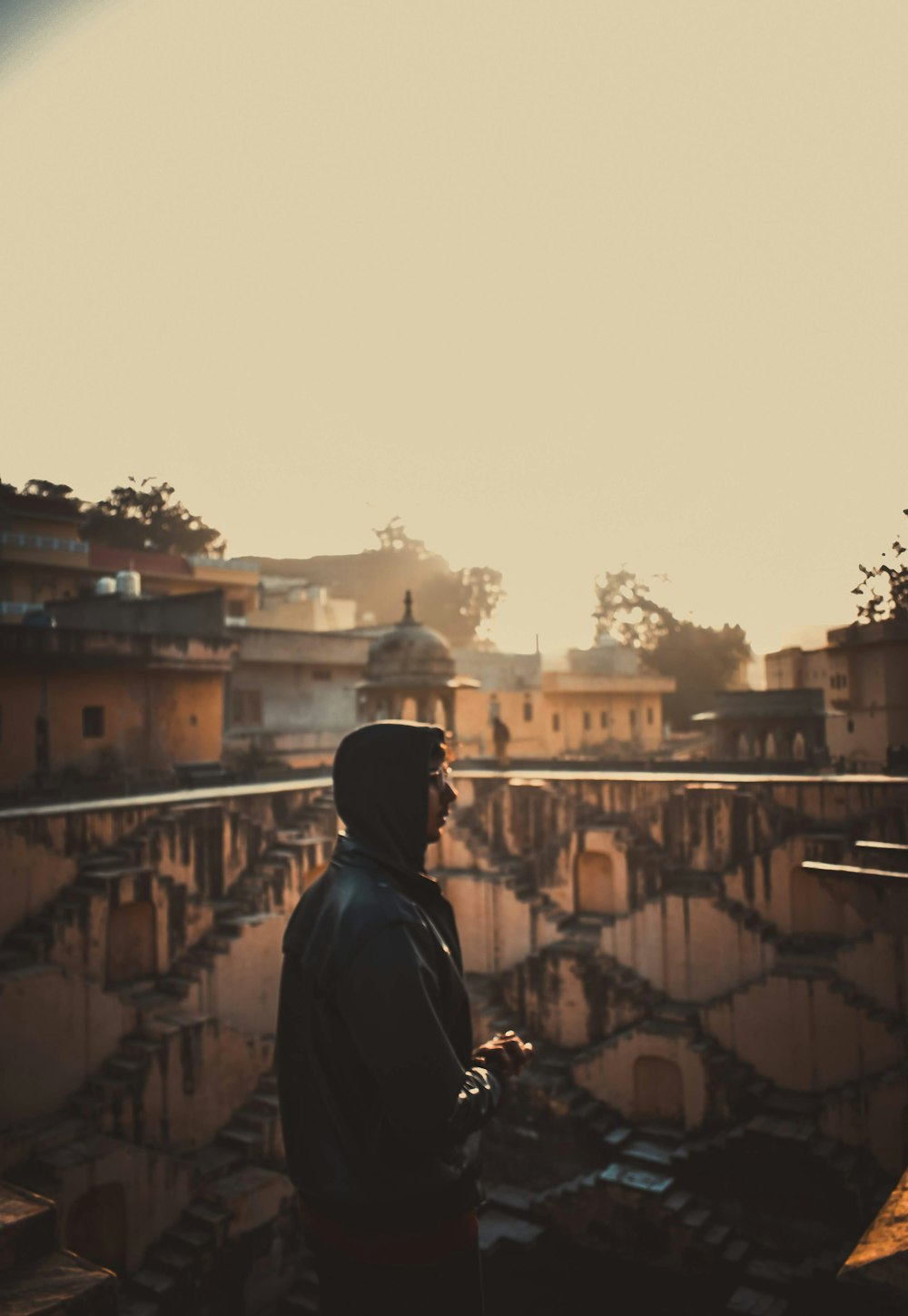 man in black hoodie standing on top of building during daytime