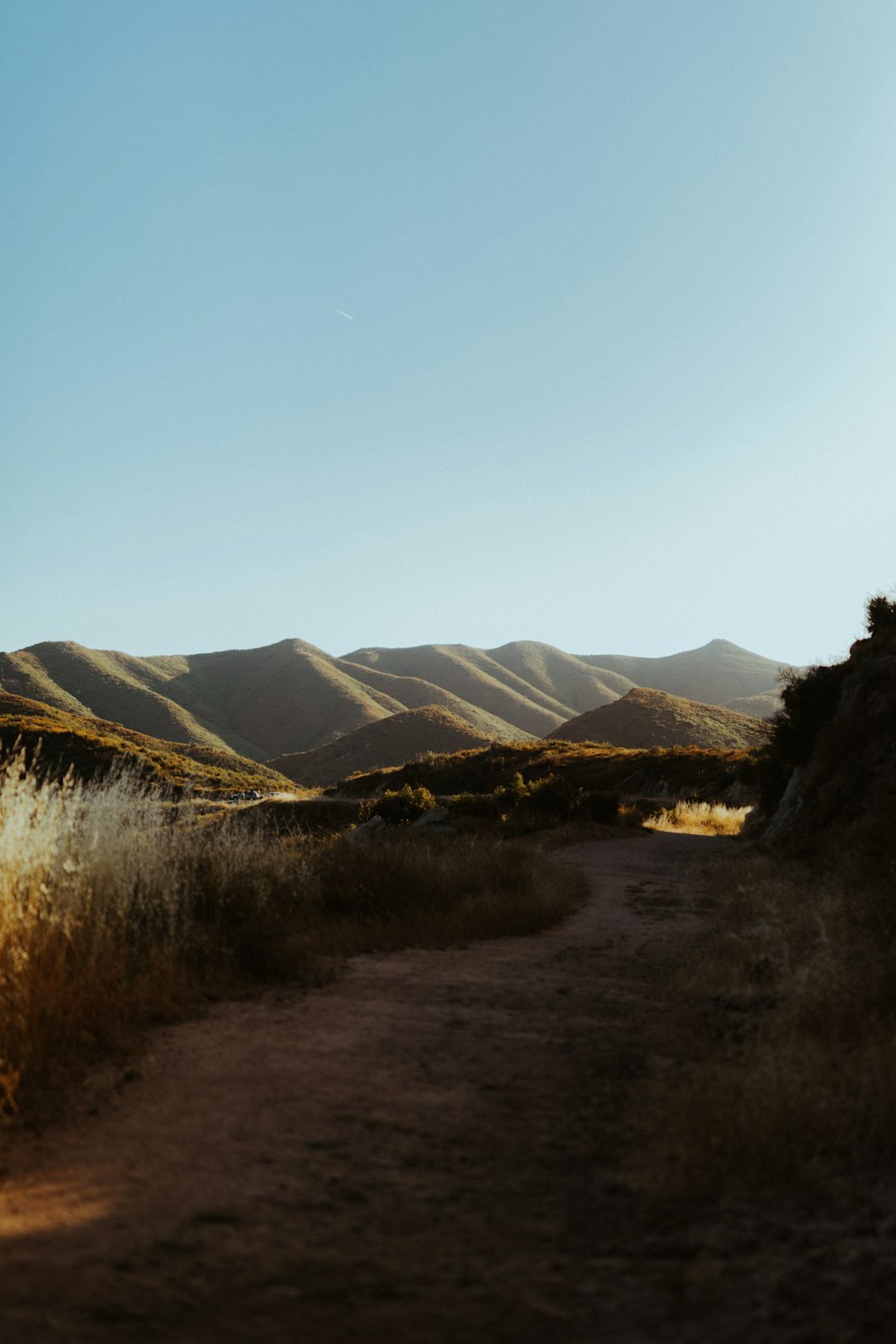 brown grass field near mountains during daytime