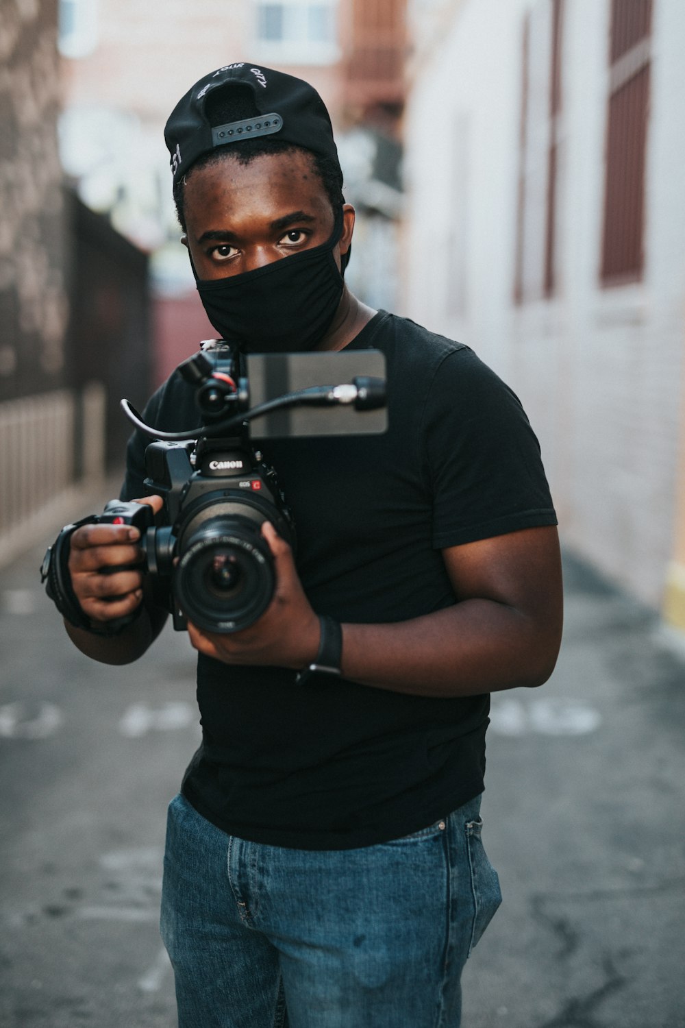 man in black crew neck t-shirt holding black dslr camera