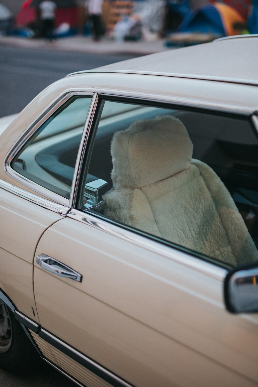 woman in beige fur coat sitting on car