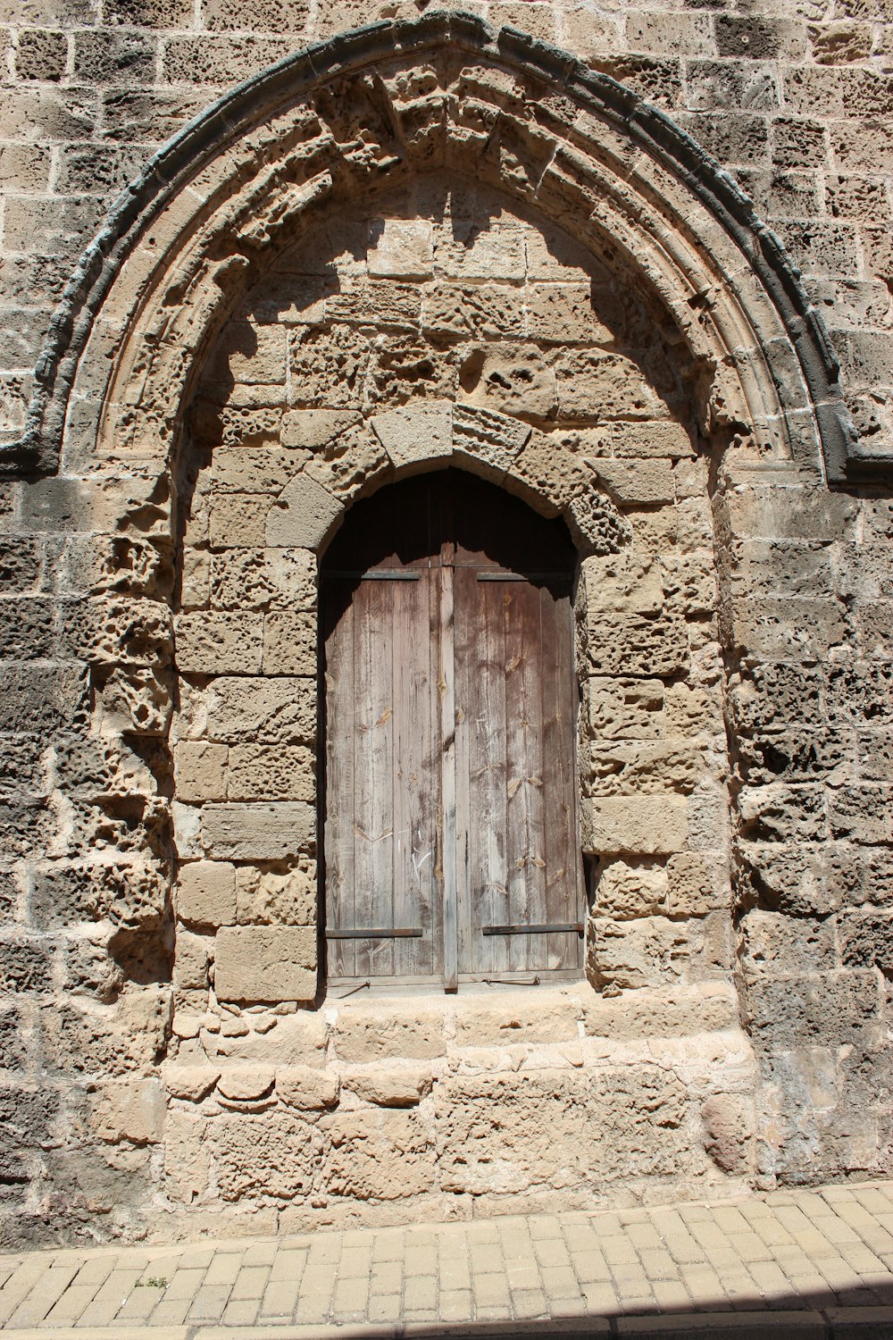 puerta de madera marrón sobre pared de ladrillo de hormigón marrón