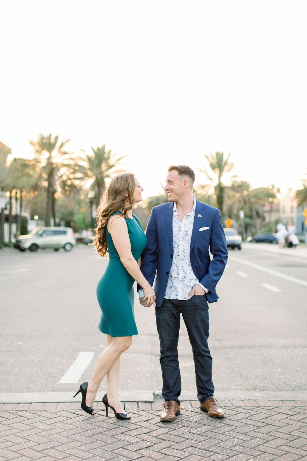 man in blue suit and woman in blue dress walking on the street during daytime