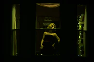 Elegant evening dress displayed on a mannequin, illuminated softly against a dark background.